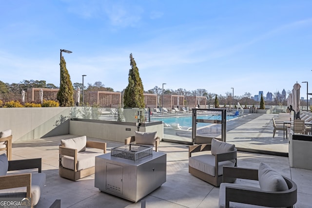 2425 Peachtree Rd NE Unit 903, Atlanta, GA 30305 - view of patio / terrace with a community pool, an outdoor living space with a fire pit, and fence