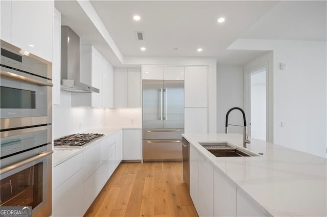 2425 Peachtree Rd NE Unit 903, Atlanta, GA 30305 - kitchen with modern cabinets, a sink, white cabinetry, stainless steel appliances, and wall chimney range hood