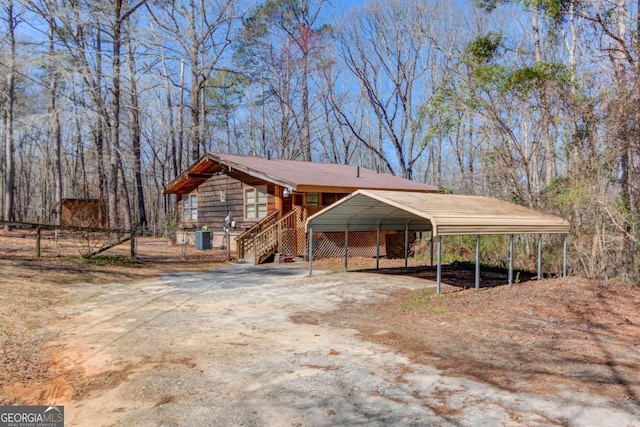 view of front of house featuring driveway, a carport, and central air condition unit