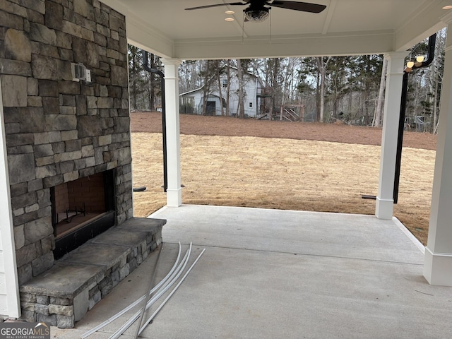 view of patio / terrace with an outdoor stone fireplace and a ceiling fan