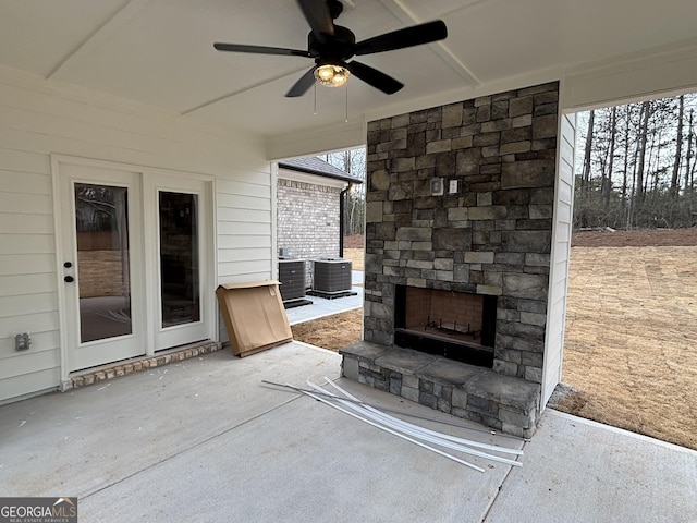 view of patio featuring a ceiling fan and an outdoor stone fireplace