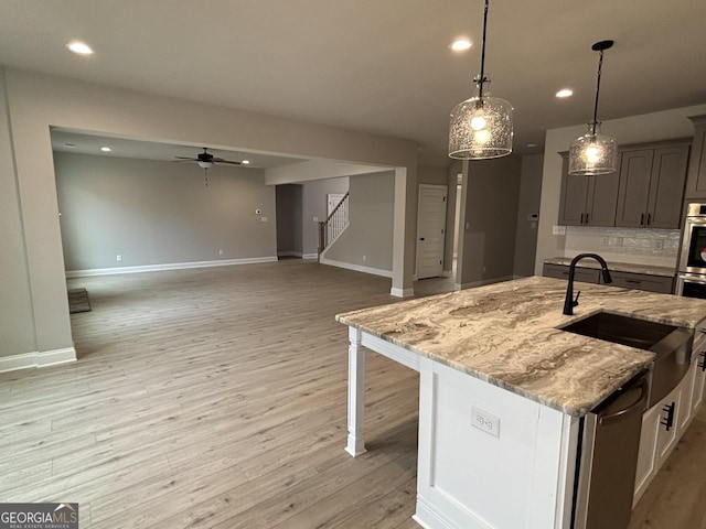 kitchen with light wood finished floors, backsplash, a sink, and recessed lighting