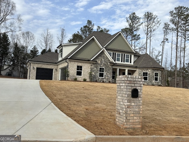 craftsman house featuring a garage, driveway, stone siding, and a front yard