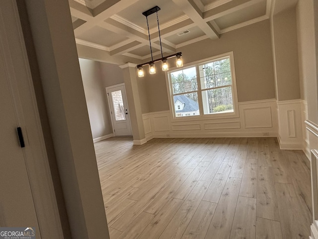 unfurnished dining area with beam ceiling, coffered ceiling, a decorative wall, and light wood finished floors