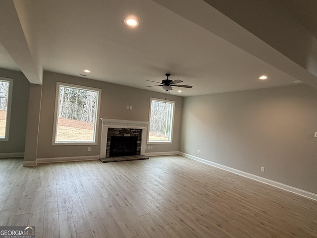 unfurnished living room with recessed lighting, a fireplace, baseboards, and wood finished floors