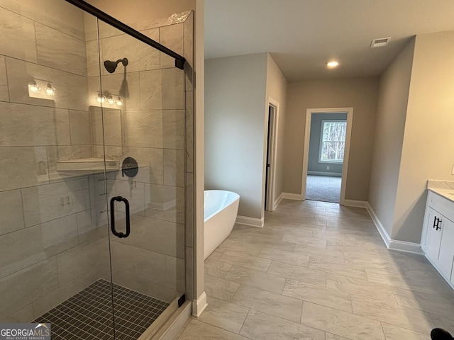 bathroom featuring baseboards, visible vents, a freestanding bath, vanity, and a shower stall