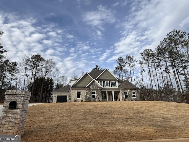 view of front facade featuring stone siding, a front lawn, and an attached garage