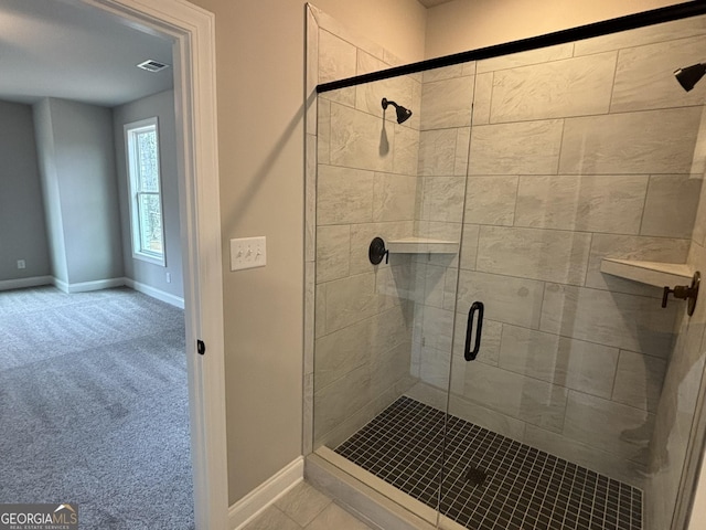 bathroom with a shower stall, visible vents, and baseboards