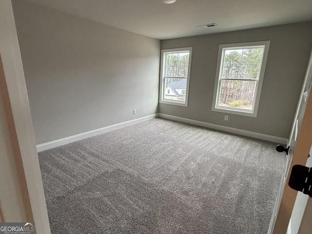 unfurnished room with baseboards, visible vents, and carpet flooring