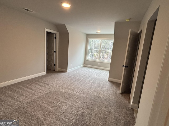 interior space featuring carpet floors, visible vents, and baseboards