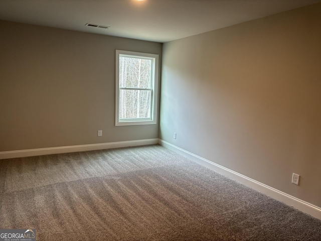 spare room featuring carpet floors, baseboards, and visible vents