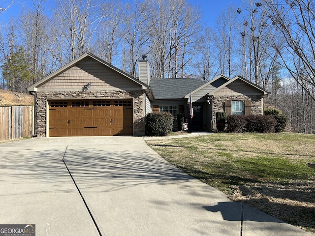 view of front of home featuring a garage, stone siding, and driveway