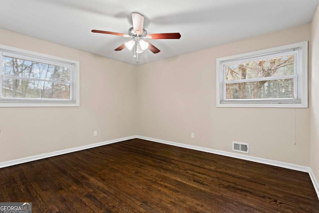 empty room featuring visible vents, ceiling fan, baseboards, and wood finished floors