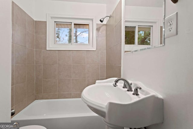 bathroom with  shower combination, plenty of natural light, toilet, and a sink