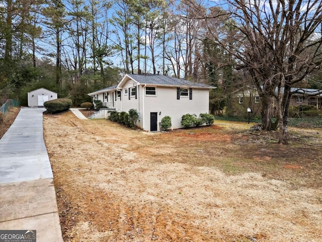 view of side of home featuring a storage shed, an outdoor structure, and a detached garage