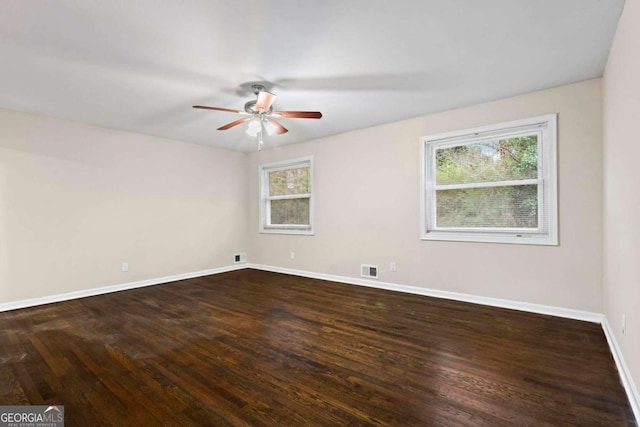 spare room with plenty of natural light, dark wood finished floors, and baseboards