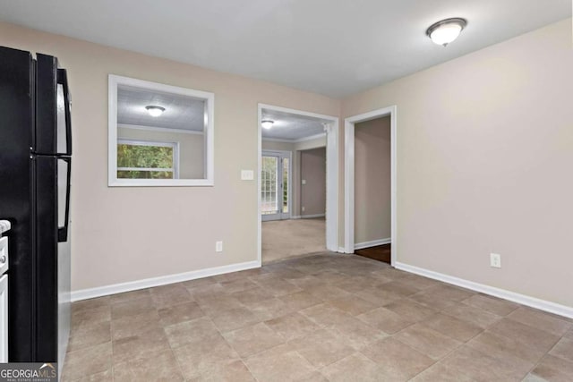 spare room with ornamental molding and baseboards