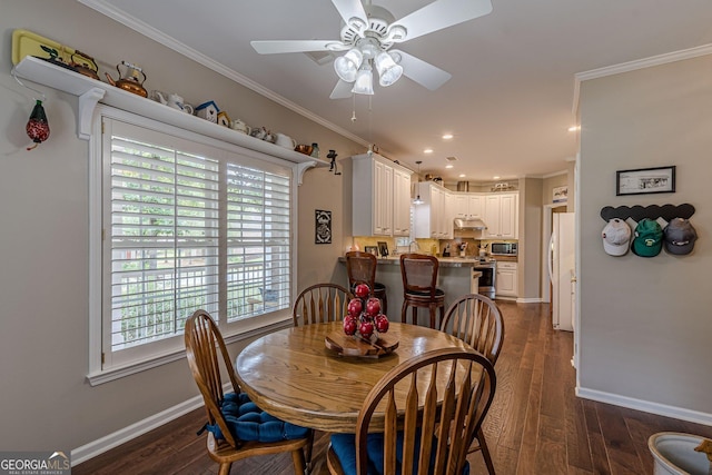 dining area featuring dark wood-type flooring, crown molding, and baseboards