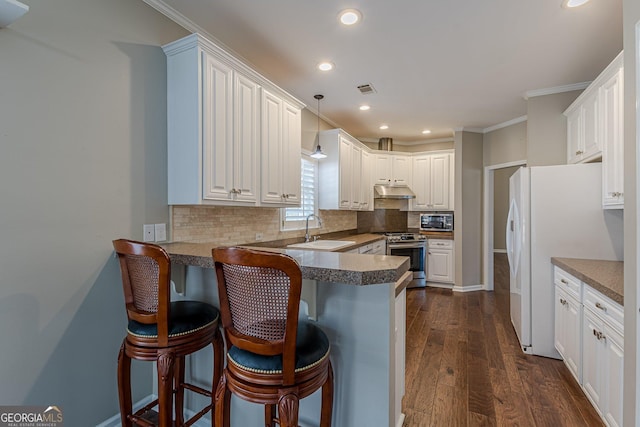 kitchen featuring stainless steel appliances, hanging light fixtures, white cabinets, a sink, and a peninsula