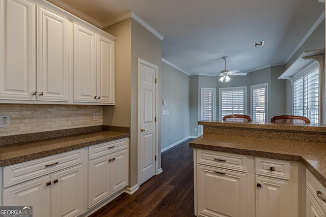 kitchen with visible vents, ceiling fan, dark wood-style flooring, crown molding, and white cabinetry