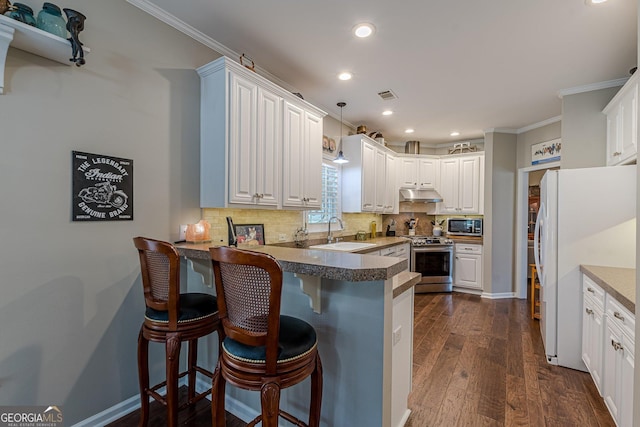 kitchen with a peninsula, a sink, white cabinetry, a kitchen breakfast bar, and appliances with stainless steel finishes