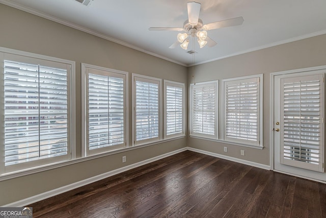 spare room featuring ornamental molding, dark wood-style flooring, baseboards, and a ceiling fan