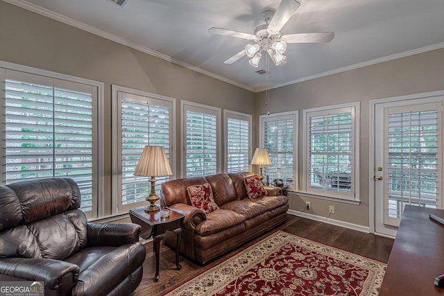 living area featuring a healthy amount of sunlight, a ceiling fan, ornamental molding, and dark wood-style flooring