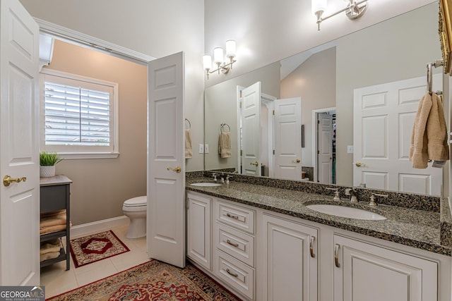 full bathroom with double vanity, tile patterned flooring, toilet, and a sink