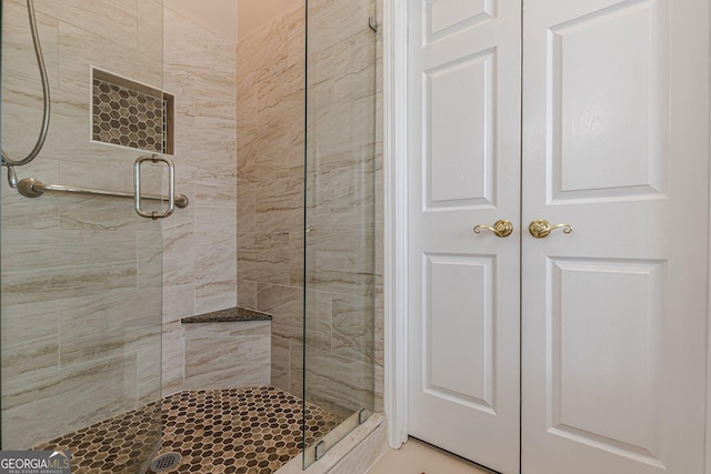 bathroom featuring a closet and a shower stall