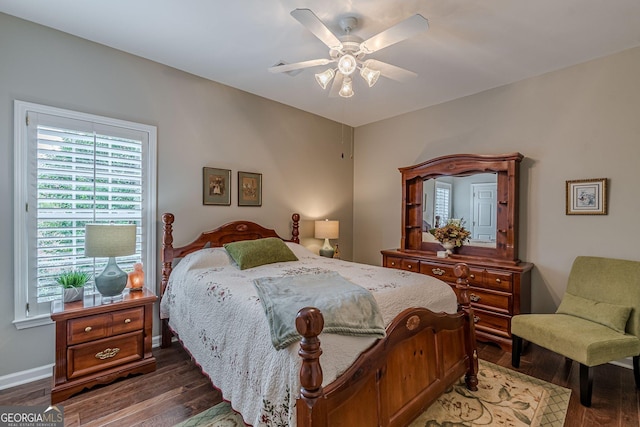 bedroom with dark wood-style flooring, a ceiling fan, and baseboards