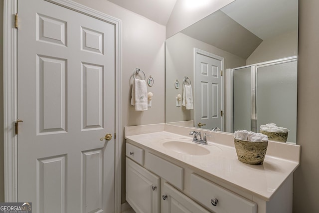 bathroom with lofted ceiling, a stall shower, and vanity