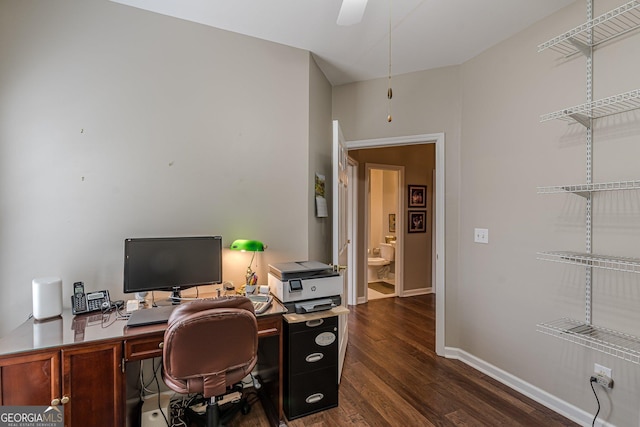 office space with a ceiling fan, baseboards, and dark wood-type flooring