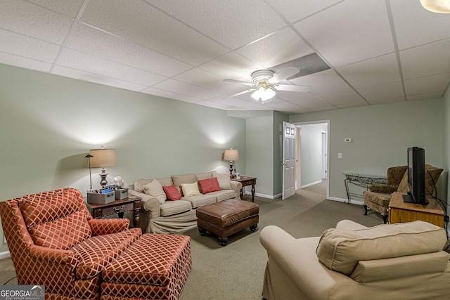 living area with carpet, a paneled ceiling, baseboards, and ceiling fan