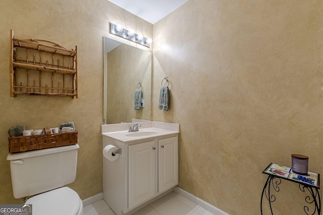 bathroom with vanity, tile patterned flooring, toilet, and baseboards