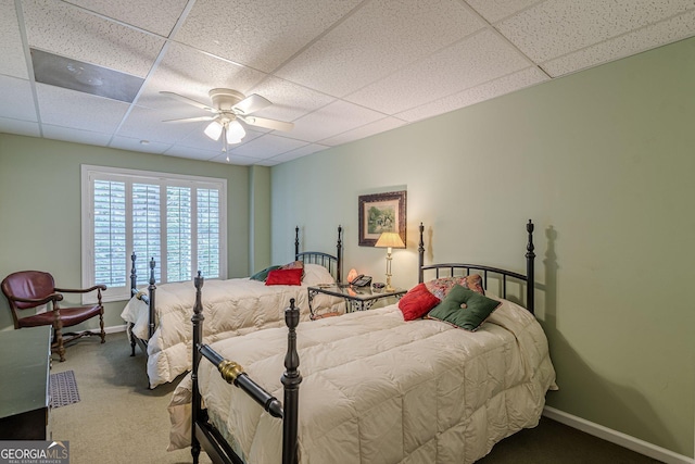 carpeted bedroom with baseboards, a paneled ceiling, and a ceiling fan