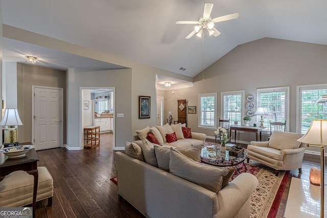 living area featuring plenty of natural light, dark wood finished floors, a ceiling fan, and baseboards