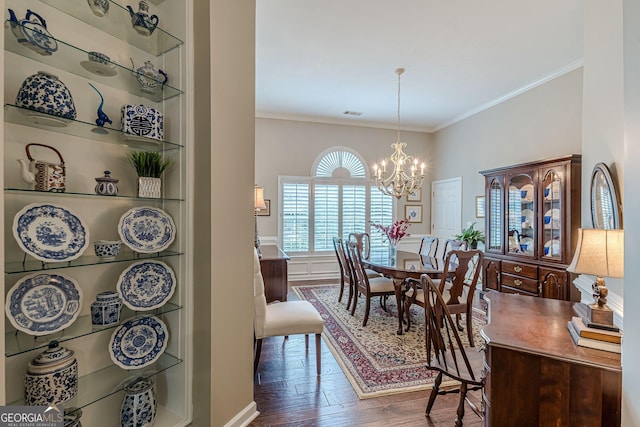 dining area featuring a chandelier, dark wood finished floors, ornamental molding, and built in features