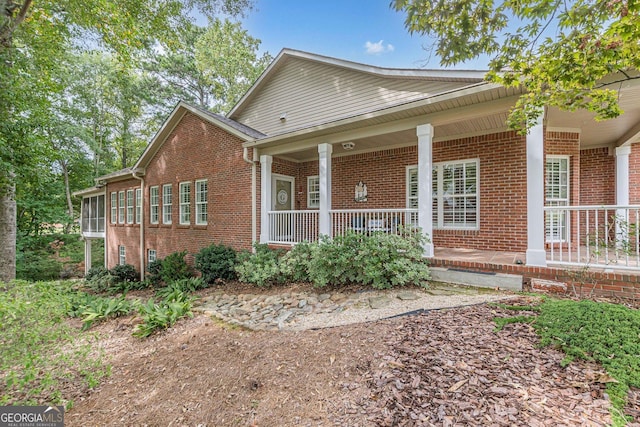 view of front of home featuring a porch and brick siding