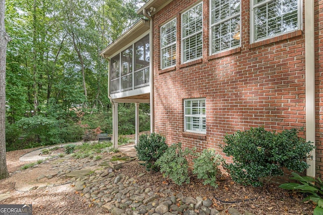 view of home's exterior featuring a sunroom and brick siding