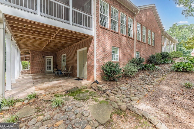 back of property with a patio area and brick siding