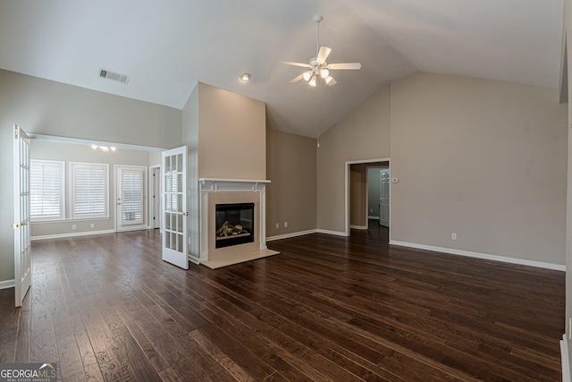 unfurnished living room with dark wood finished floors, visible vents, a fireplace with flush hearth, high vaulted ceiling, and baseboards