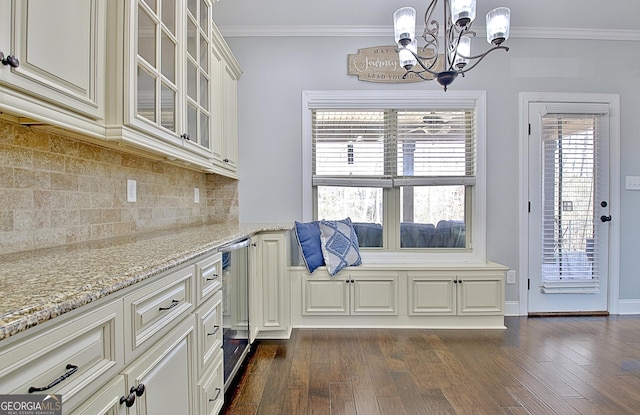 interior space featuring tasteful backsplash, dark wood finished floors, glass insert cabinets, light stone countertops, and crown molding