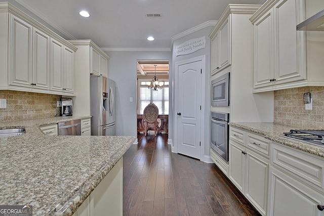 kitchen featuring dark wood-style floors, light stone countertops, stainless steel appliances, crown molding, and wall chimney range hood