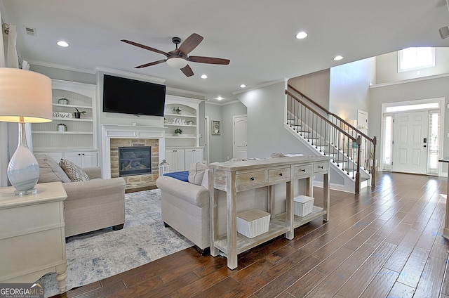 living area with dark wood-style flooring, ornamental molding, stairway, and recessed lighting