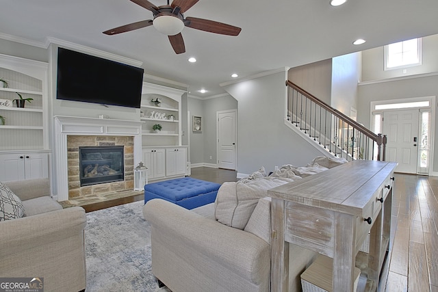 living room featuring ornamental molding, stairway, baseboards, and wood finished floors