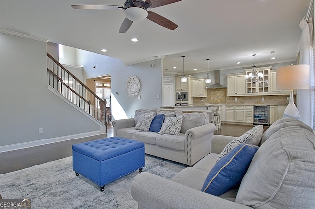 living area featuring stairway, ornamental molding, wood finished floors, beverage cooler, and baseboards