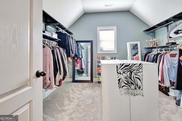 spacious closet with vaulted ceiling, carpet floors, and visible vents