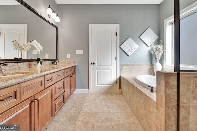 bathroom with double vanity, a garden tub, a sink, and tile patterned floors