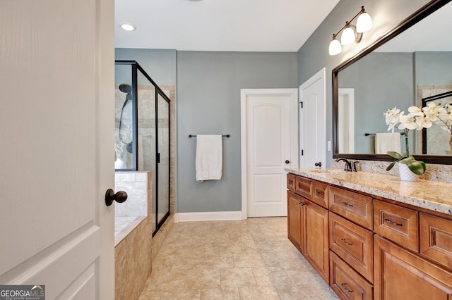 full bathroom featuring a stall shower, vanity, and baseboards