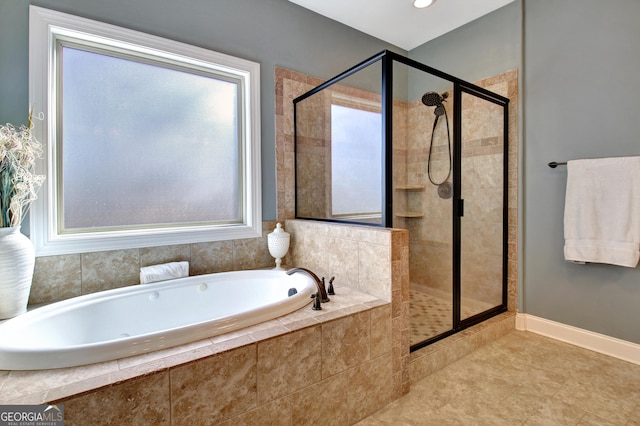 full bath featuring a garden tub, tile patterned floors, a shower stall, and baseboards